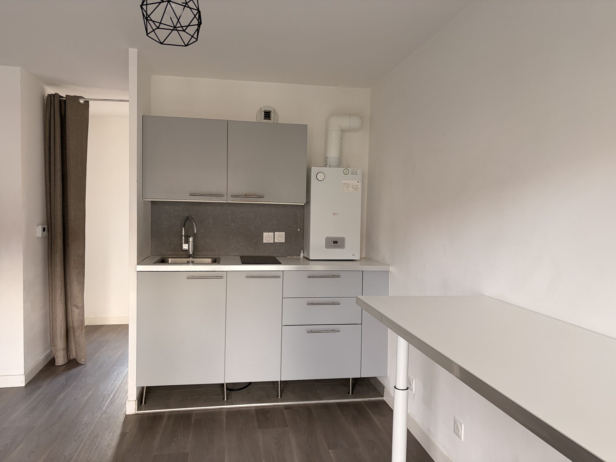 Kitchenette équipée avec plaques à induction et meubles hauts